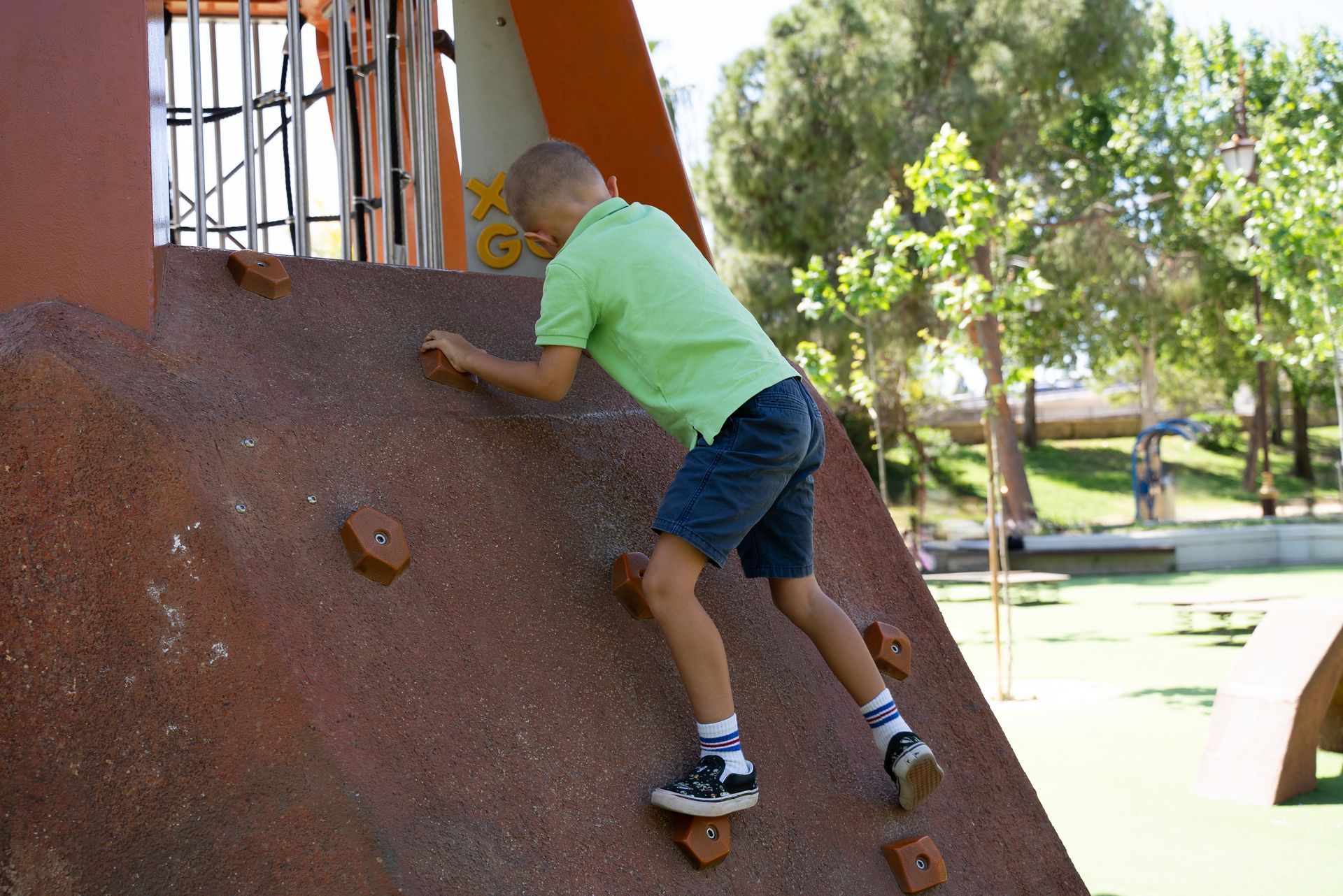 Enfant escaladant un mur d'aire de jeux extérieur 