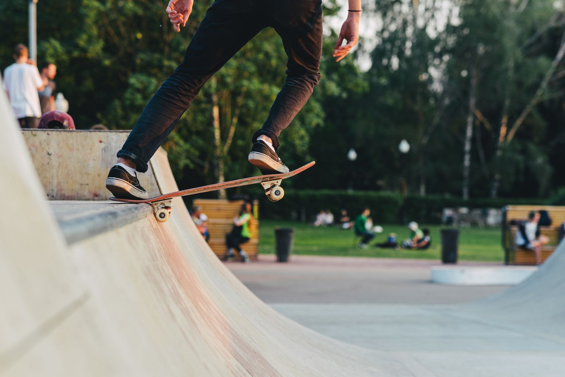 Un skateur effectue un grind sur une rampe en béton dans un skatepark