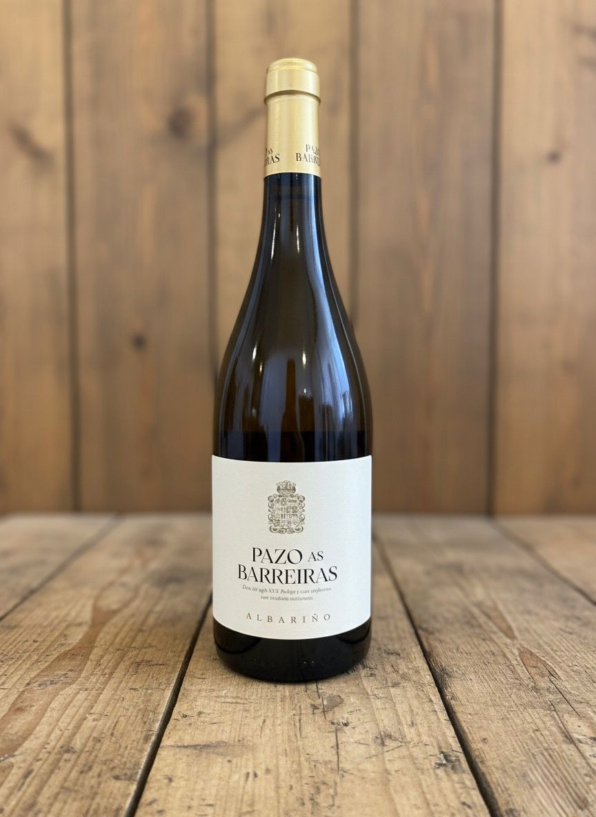 Botella de vino sobre una superficie de madera, etiqueta blanca con el texto 