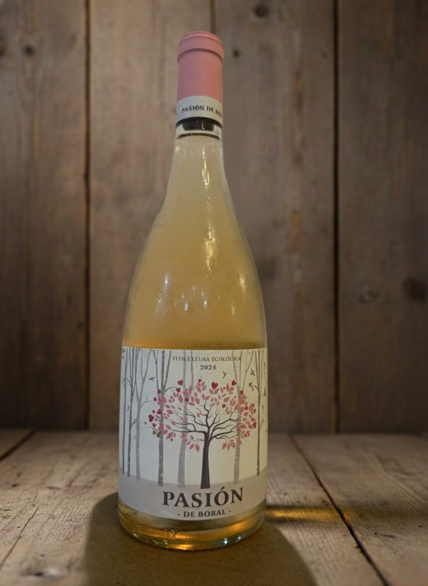 Botella de vino “Pasión”, etiqueta rosa claro con diseño de árbol, fondo de madera.