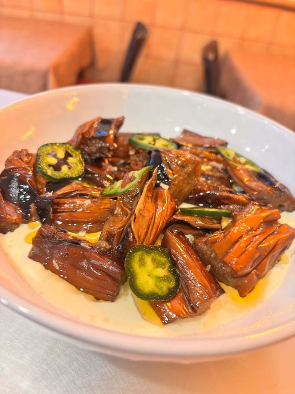 Plato de champiñones y jalapeños cocinados sobre polenta cremosa.