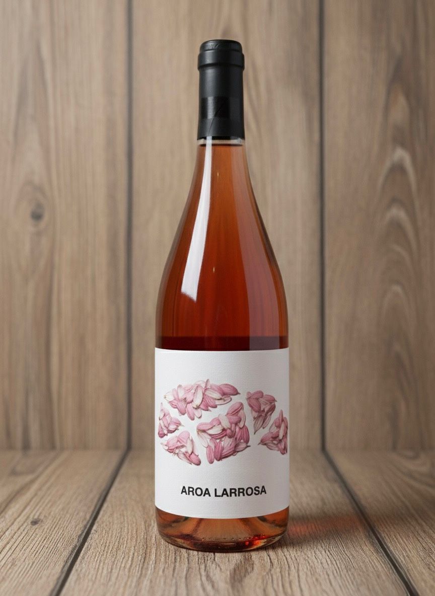 Botella de vino rosado, etiqueta “AIDA LARROSA” con diseño floral, sobre fondo de madera.