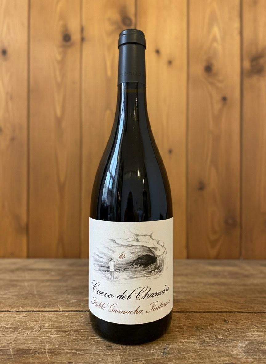 Botella de vino con etiqueta blanca sobre fondo de madera.