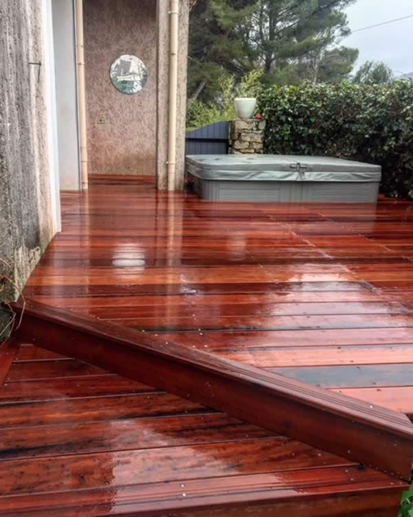 Terrasse en bois rouge sous la pluie