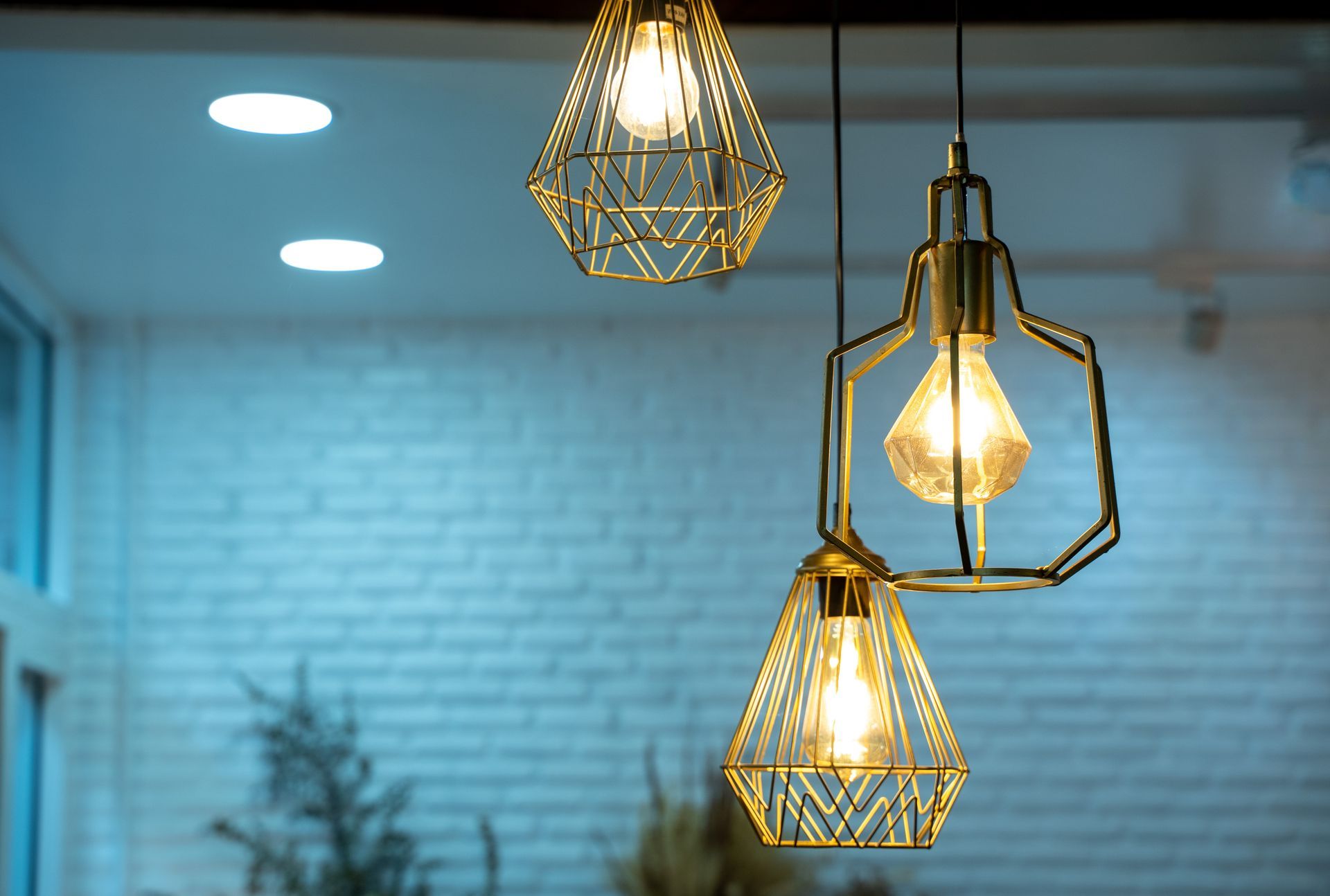 Luminaires suspendus au design géométrique diffusant douce lumière dans une pièce au carrelage métro.