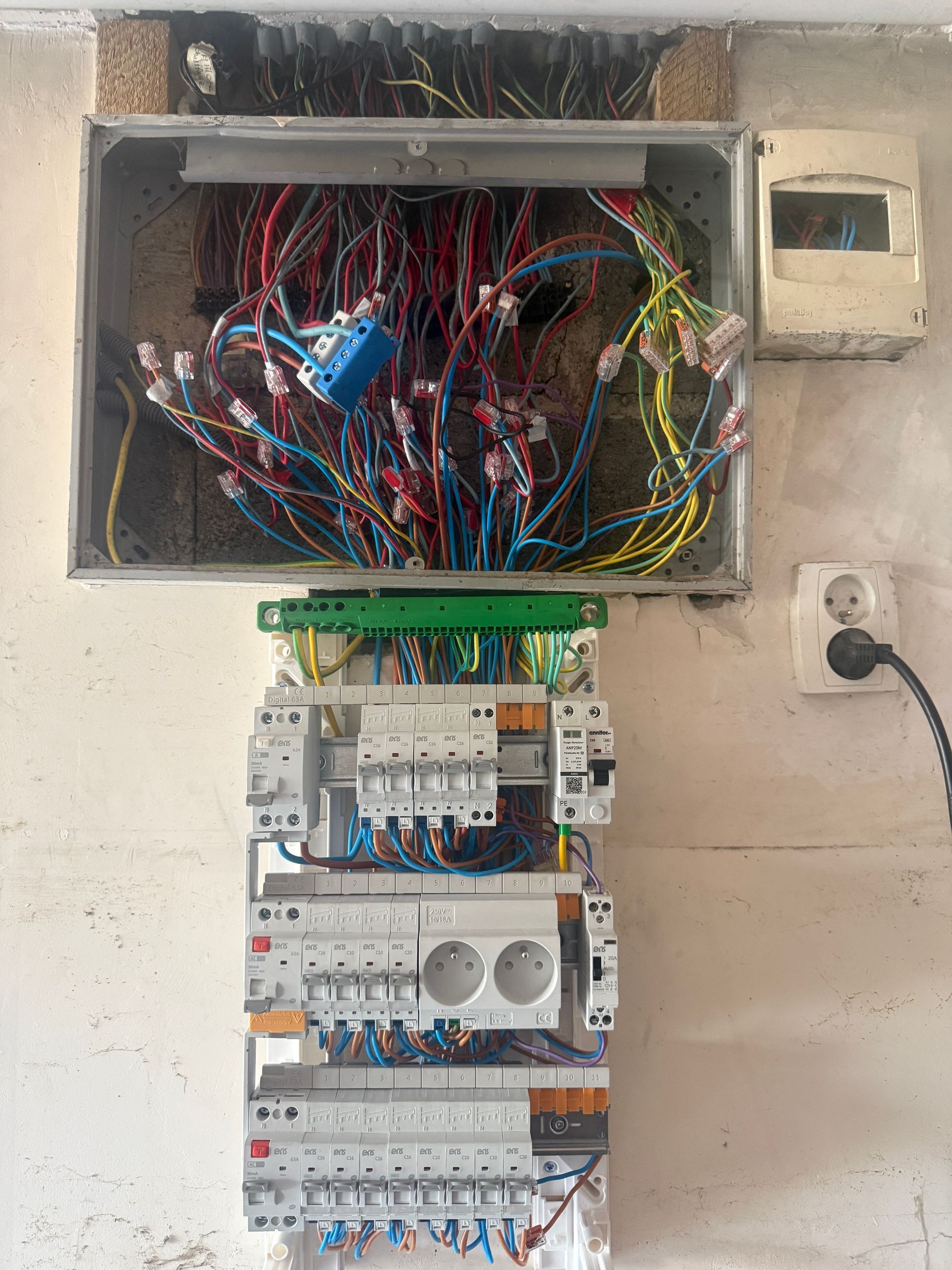 Tableau électrique ouvert avec câblage apparent, dans le cadre d'une rénovation électrique.