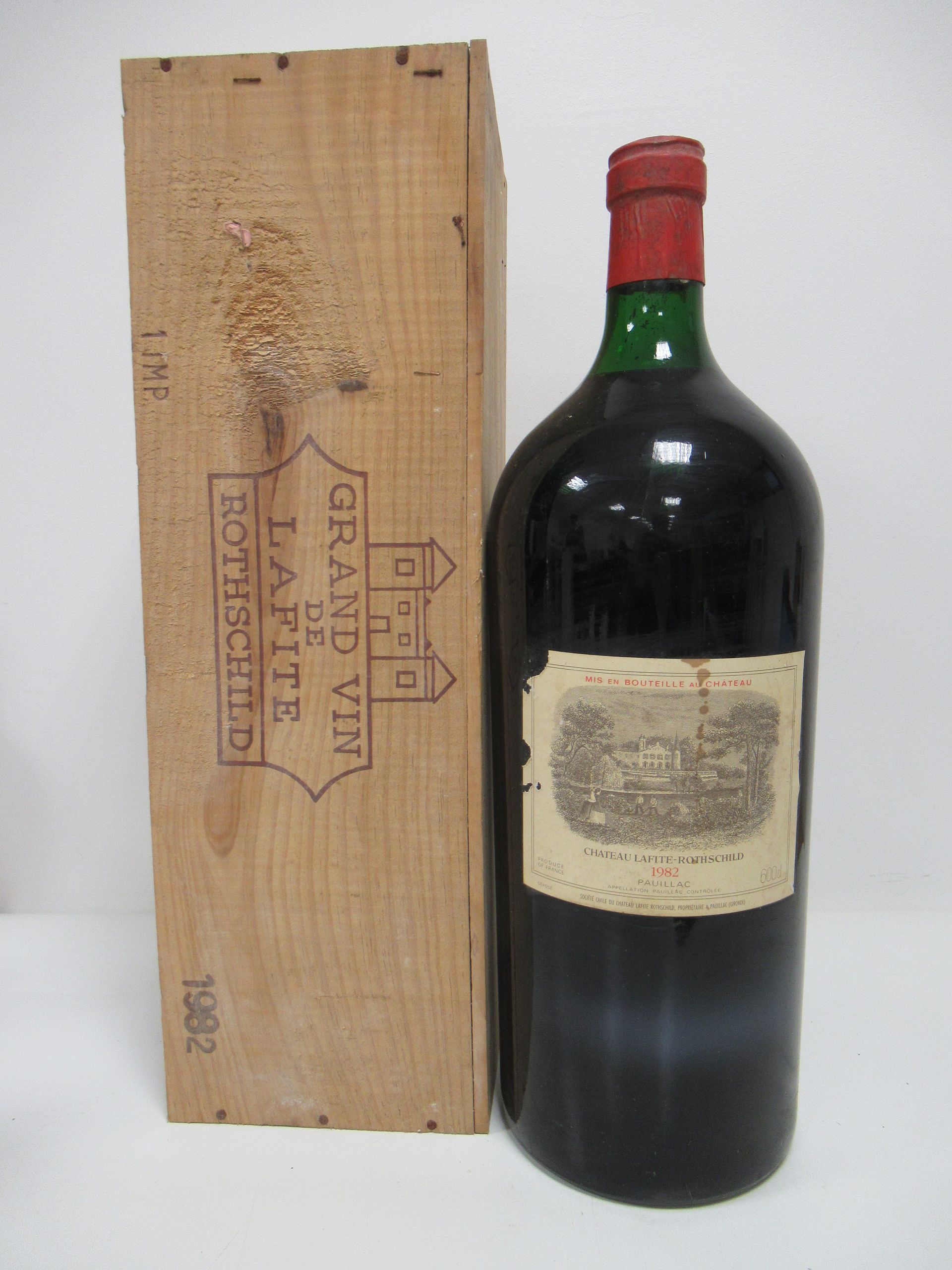 Une grande bouteille de vin rouge, étiquetée « Château Lafite Rothschild »  à côté d'une caisse en bois