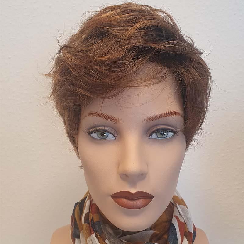 Eine Schaufensterpuppe trägt eine Perücke und ein Tuch um den Hals.