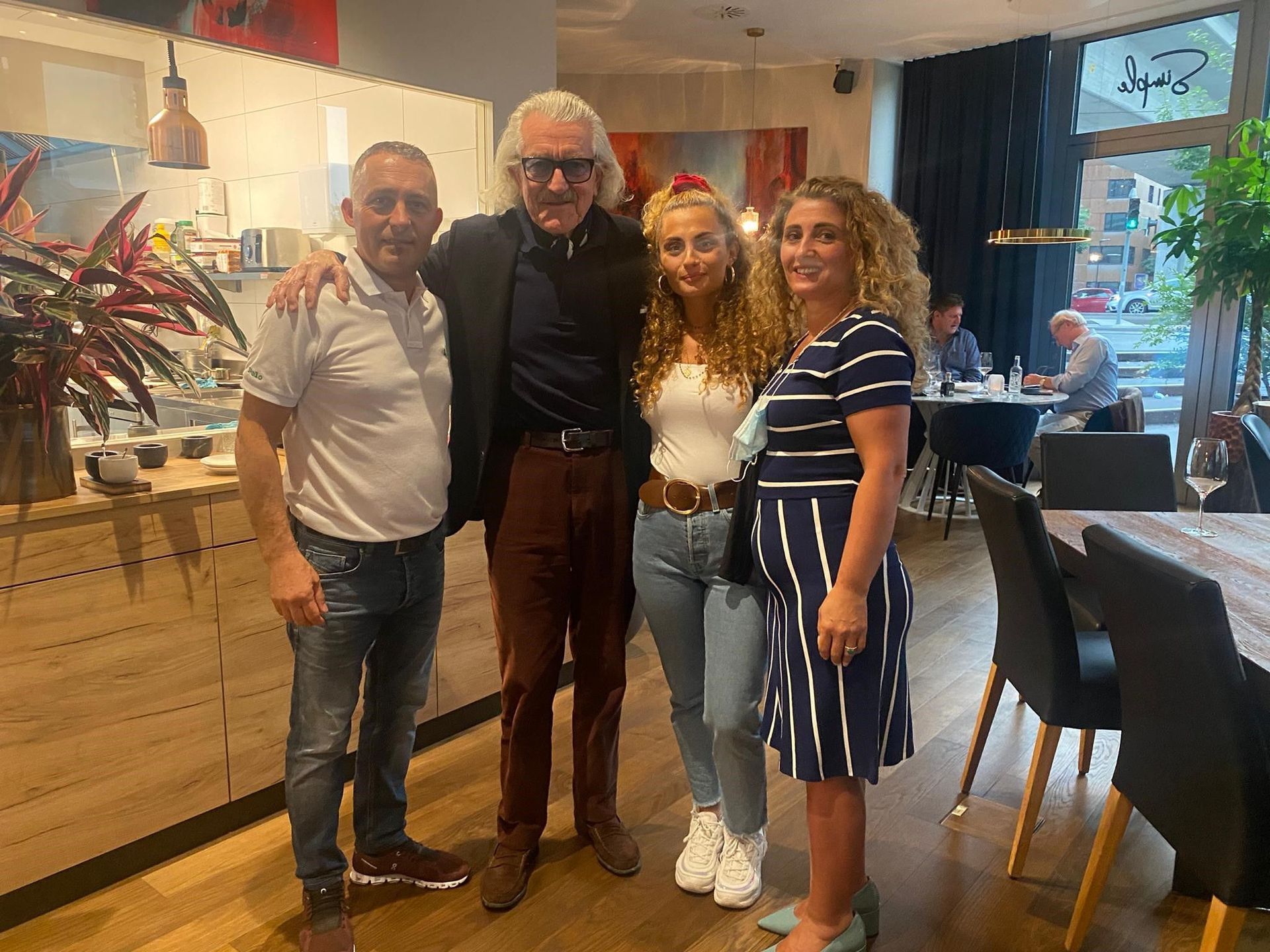 Eine Gruppe von Menschen posiert in einem Restaurant für ein Foto.