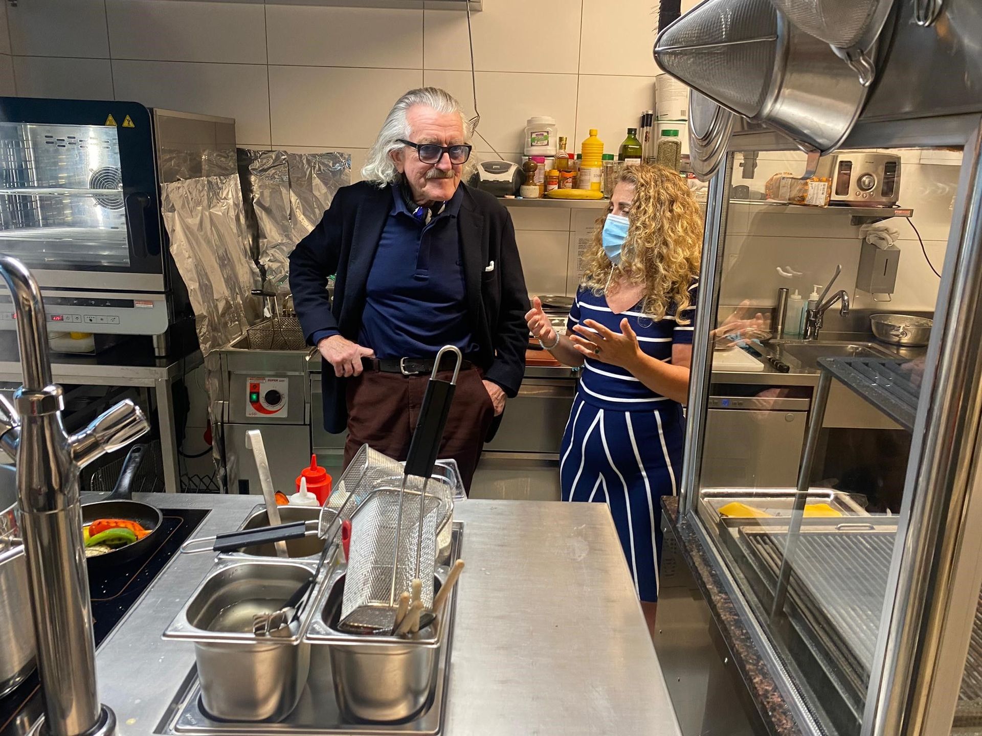 Ein Mann und eine Frau stehen in einer Küche und unterhalten sich.