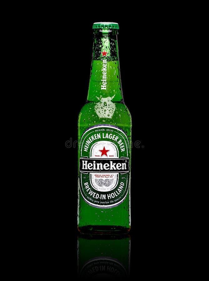 Botella de cerveza Heineken verde sobre fondo negro, con condensación y reflejo.