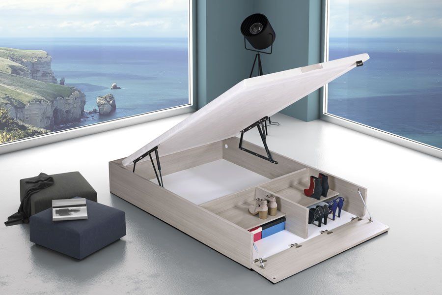 Una cama con la tapa abierta en una habitación con vista al mar.