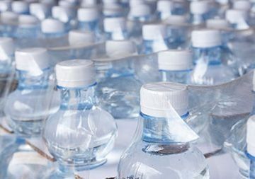 Un montón de botellas de agua colocadas una encima de otra sobre una mesa.