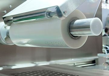 Un primer plano de un rollo de envoltura de plástico en una máquina.