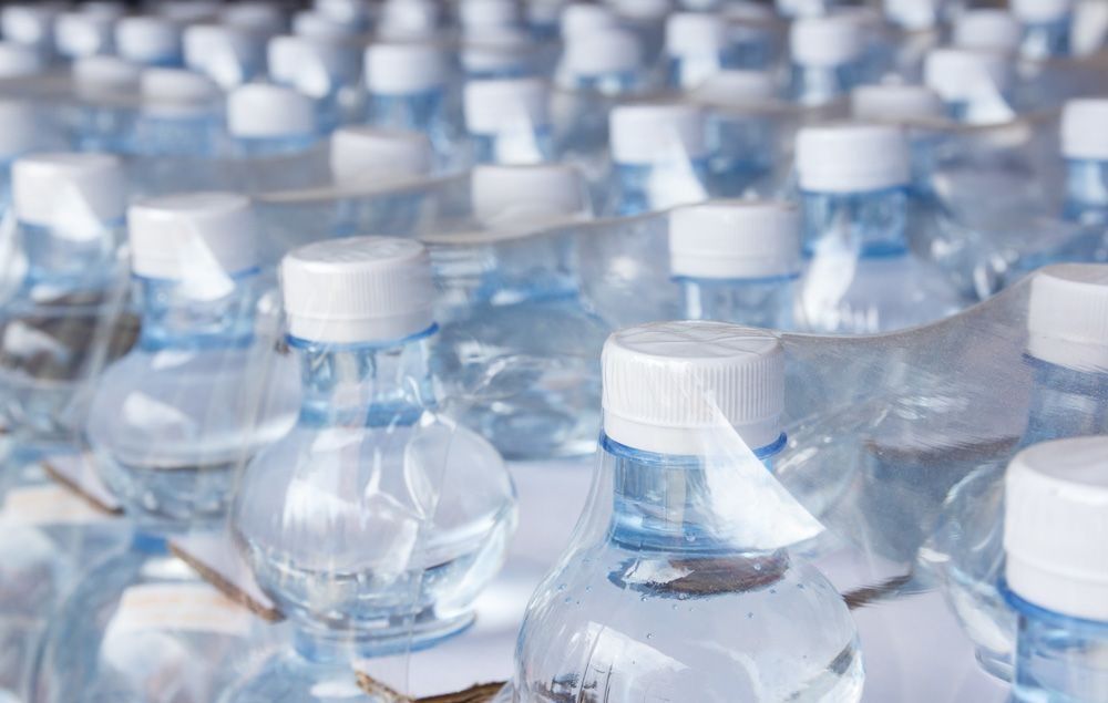 Un montón de botellas de agua colocadas una encima de otra sobre una mesa.