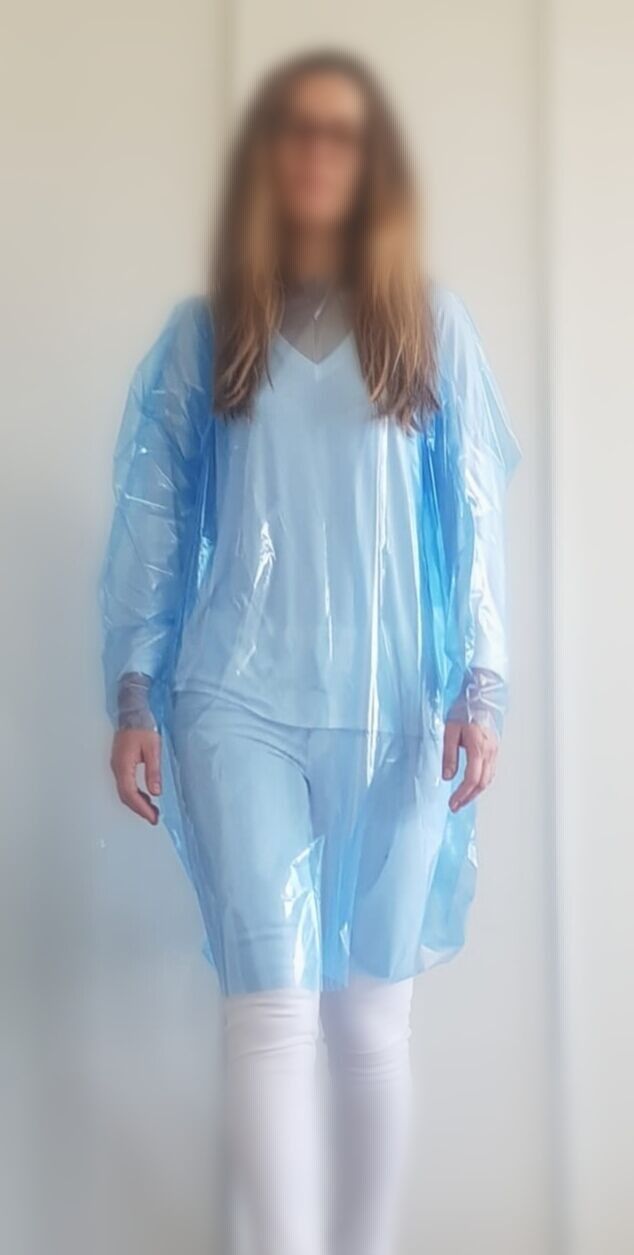 Una imagen borrosa de una mujer que lleva una bata de plástico azul.