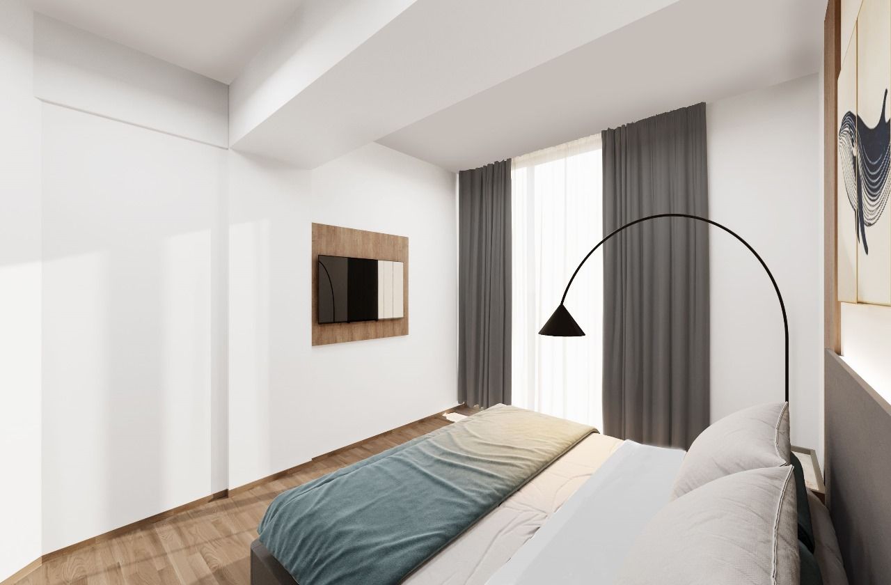 A bedroom with a large bed , a lamp , a television and a window.