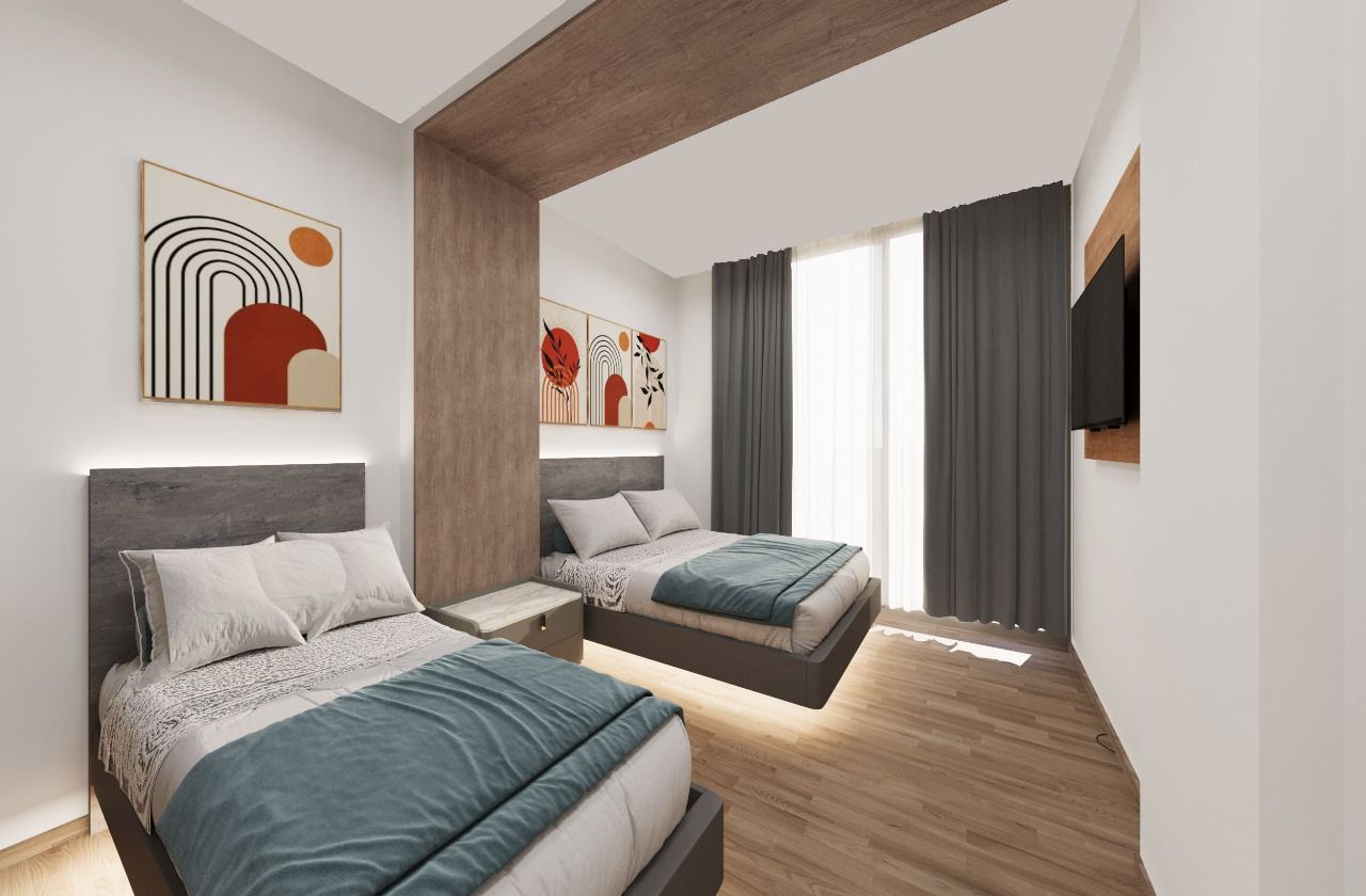 A bedroom with two beds and a television on the wall.