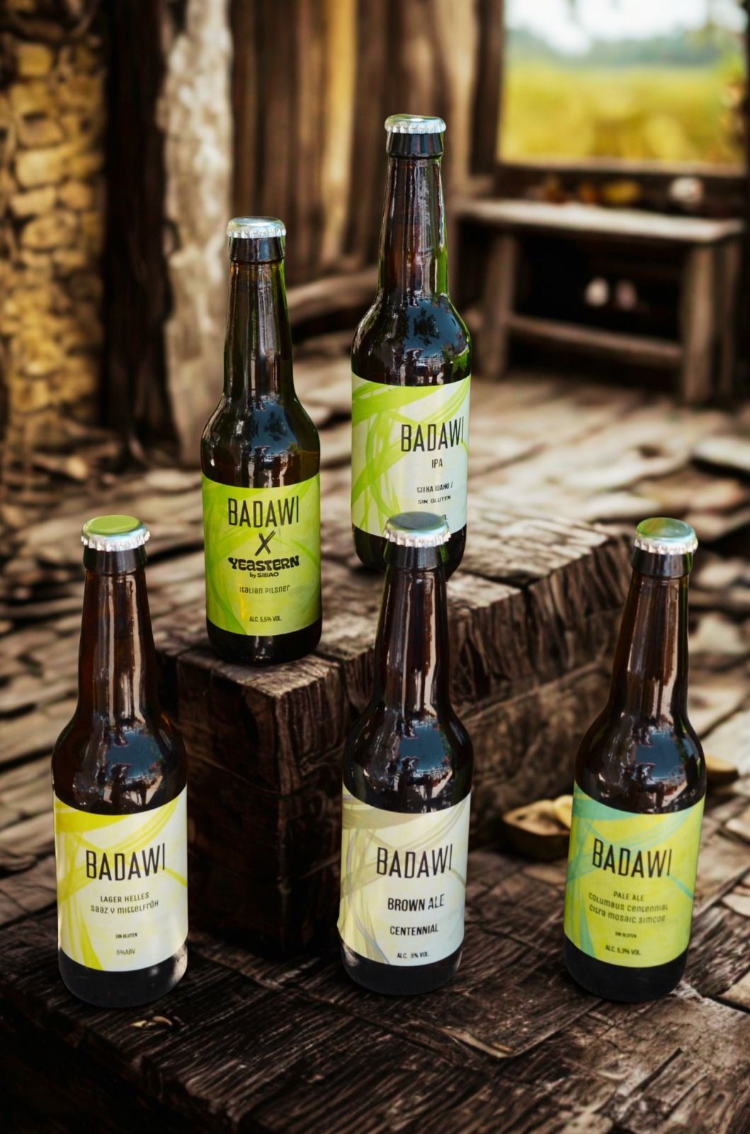 Exhibición de cerveza artesanal con botellas, vasos de cerveza ámbar, una tapa negra y un paquete de 24 unidades en caja sobre una mesa de madera.