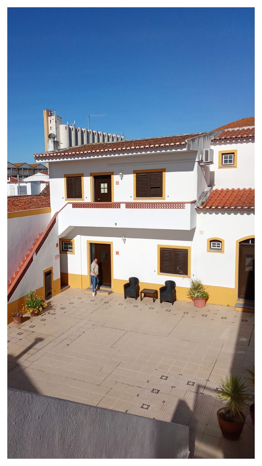 Um homem está parado em frente a um prédio branco