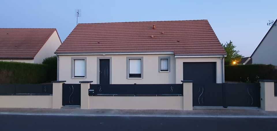 Portail en acier noir devant une maison pavillonnaire