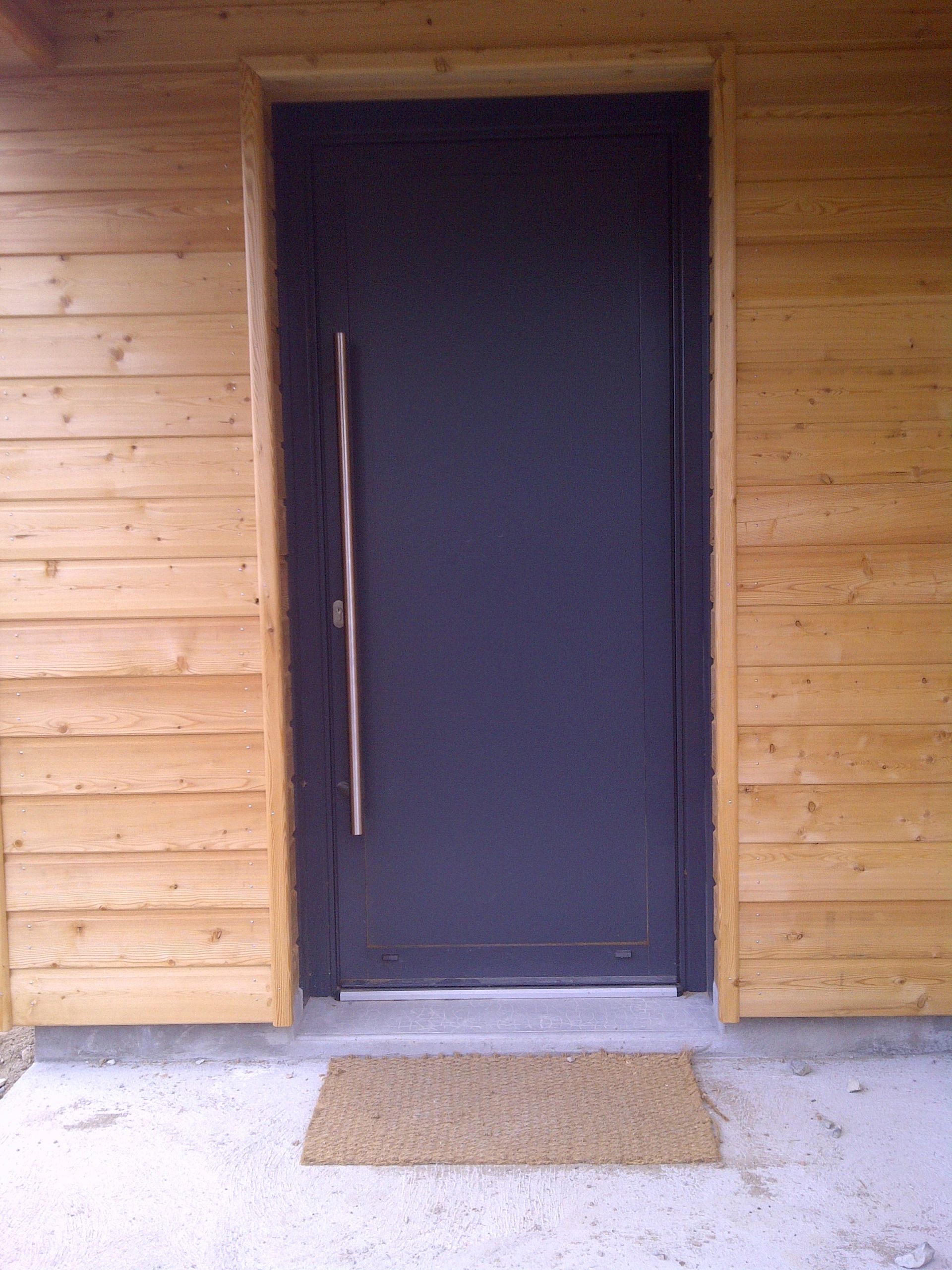 Porte d'entrée bleue avec murs en bois