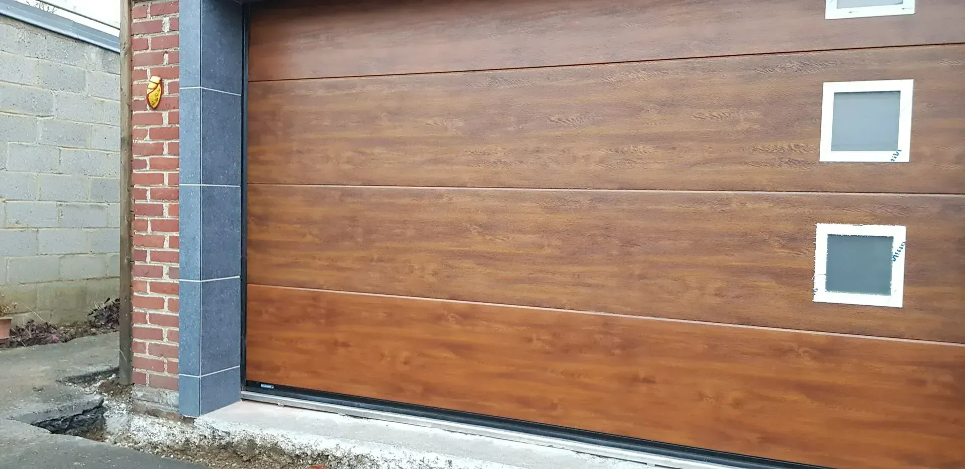 Porte de garage en bois et petites fenêtres