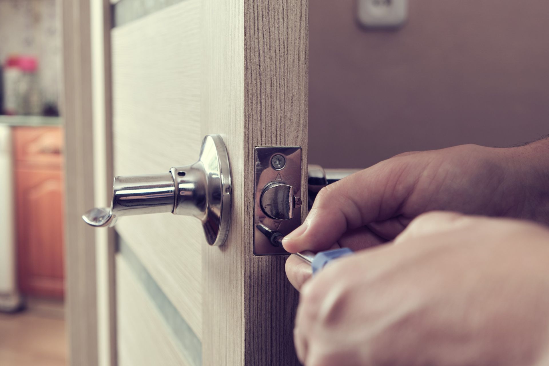 Una persona está arreglando una puerta con un destornillador.