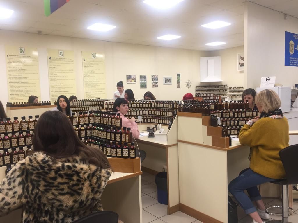 Petite boutique de détail avec des rangées d'étuis à lunettes et plusieurs personnes qui consultent les comptoirs.