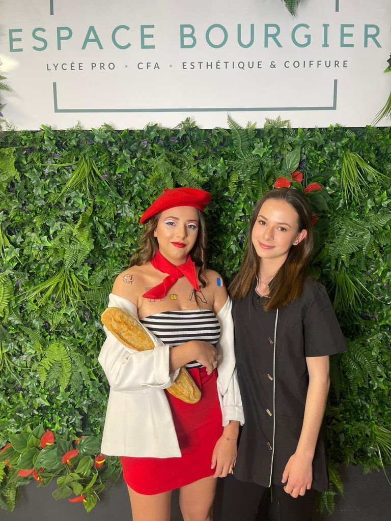 Deux femmes posent devant un décor de verdure a