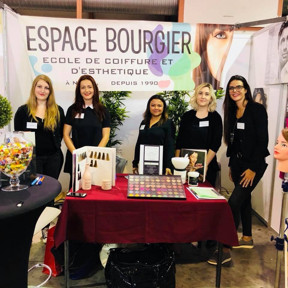 Stand commercial d'Espace Bourguier avec cinq personnes derrière une table d'exposition et une bannière