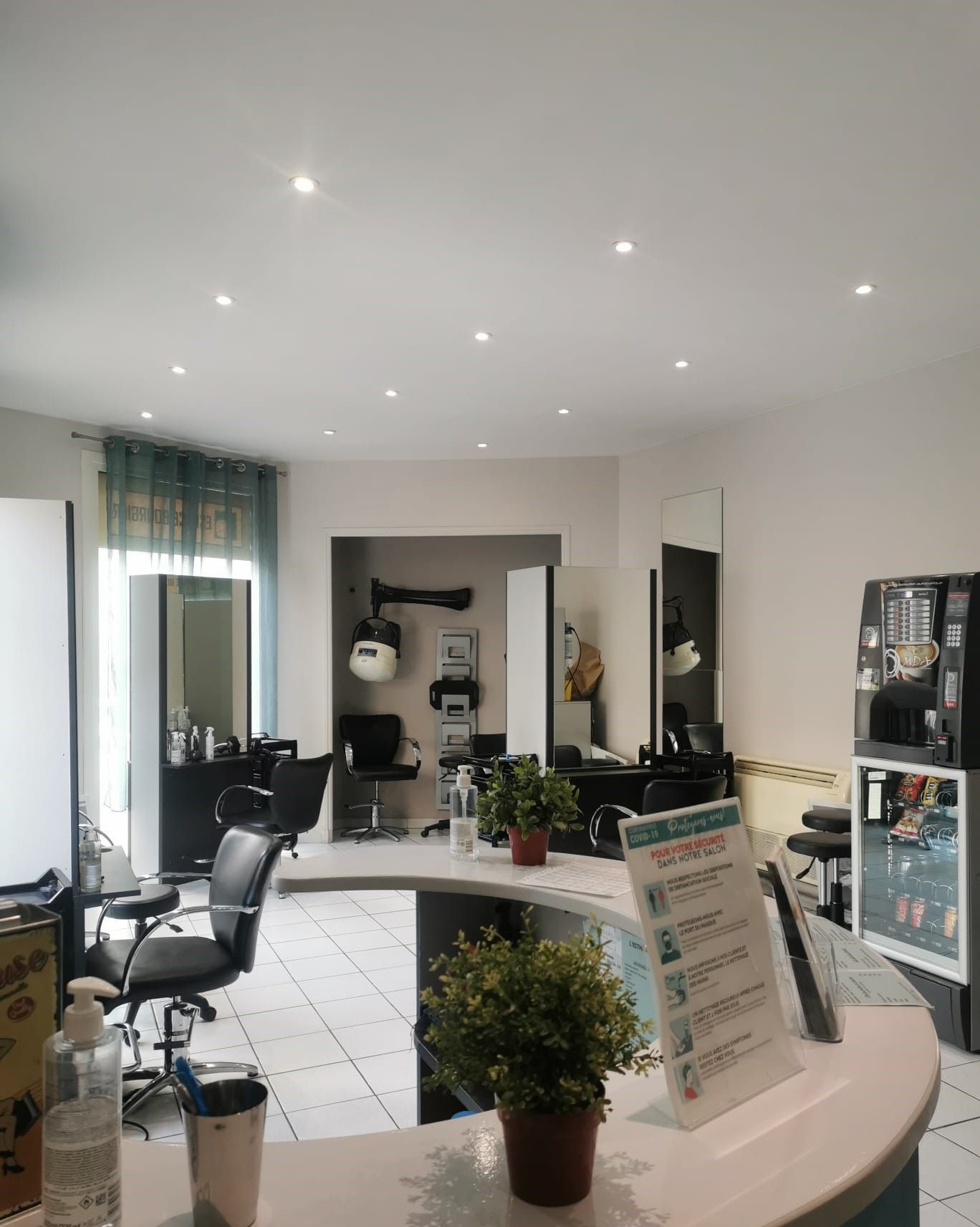 Intérieur lumineux du salon avec miroirs, fauteuils de coiffure, plantes et comptoir d'accueil
