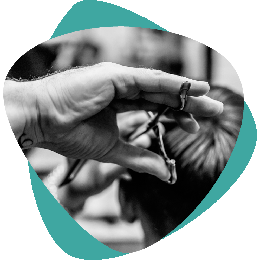 Main tenant une petite chaîne ou une lanière sur un fond noir et blanc flou, encadrée par une forme turquoise