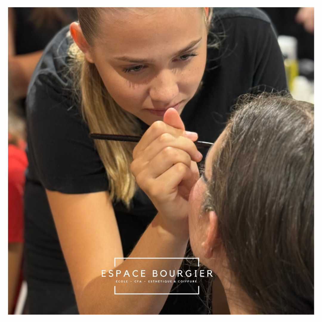 Une maquilleuse applique de l'eyeliner à une cliente assise dans un salon