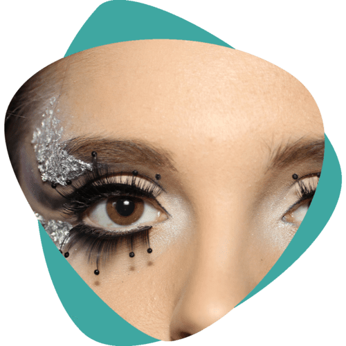 Gros plan sur un œil fortement maquillé avec des paillettes, de longs cils et un fond turquoise découpé