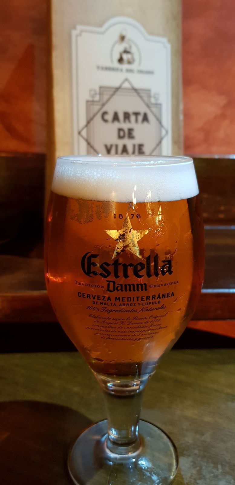 Un vaso de cerveza Estrella Damm sobre una mesa