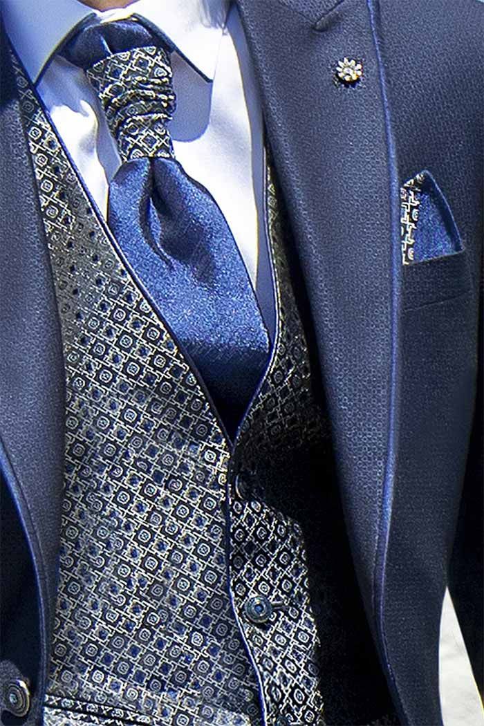 Jaqueta de vestit blava, armilla estampada i corbata amb una agulla decorativa.