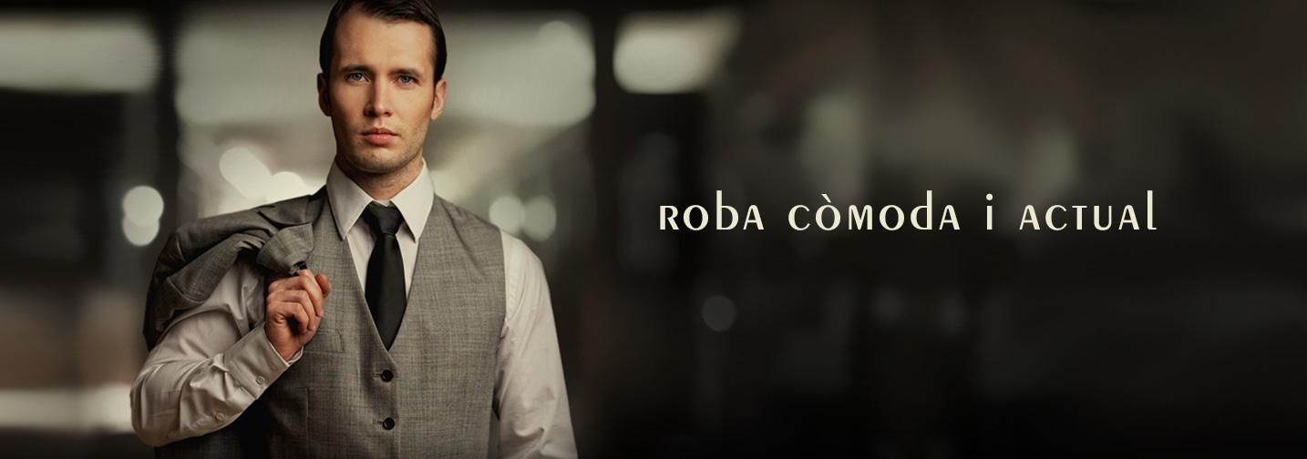 Un home amb una armilla grisa sosté una poma vermella en una habitació desenfocada amb el text «ROBA CÓMODA ACTUAL».