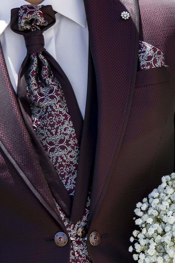 Jaqueta de vestit morada estampada amb corbata i mocador de butxaca a joc, mostrada amb flors blanques.