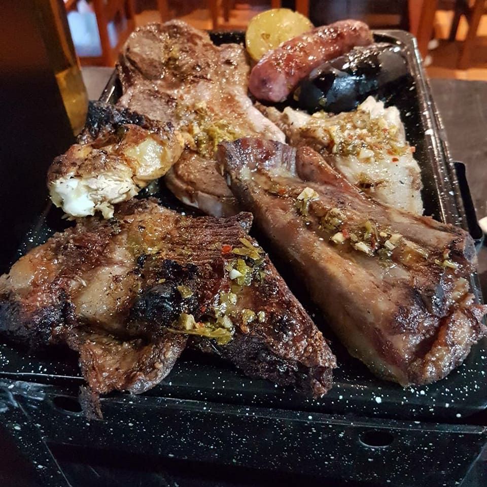 Una bandeja de carne y verduras está sobre una mesa.