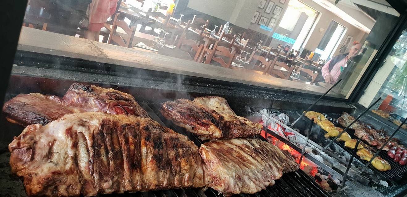 Se está cocinando un gran trozo de carne en una parrilla.