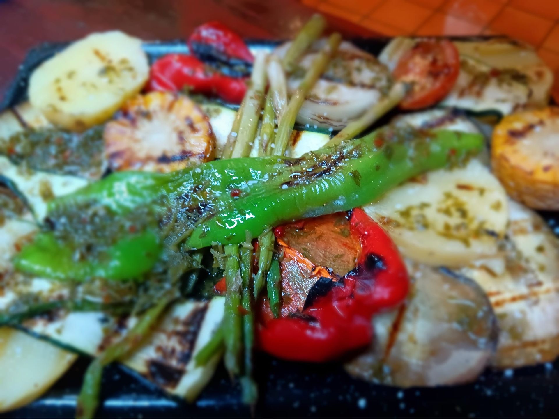Un primer plano de un plato de verduras a la parrilla sobre una mesa.