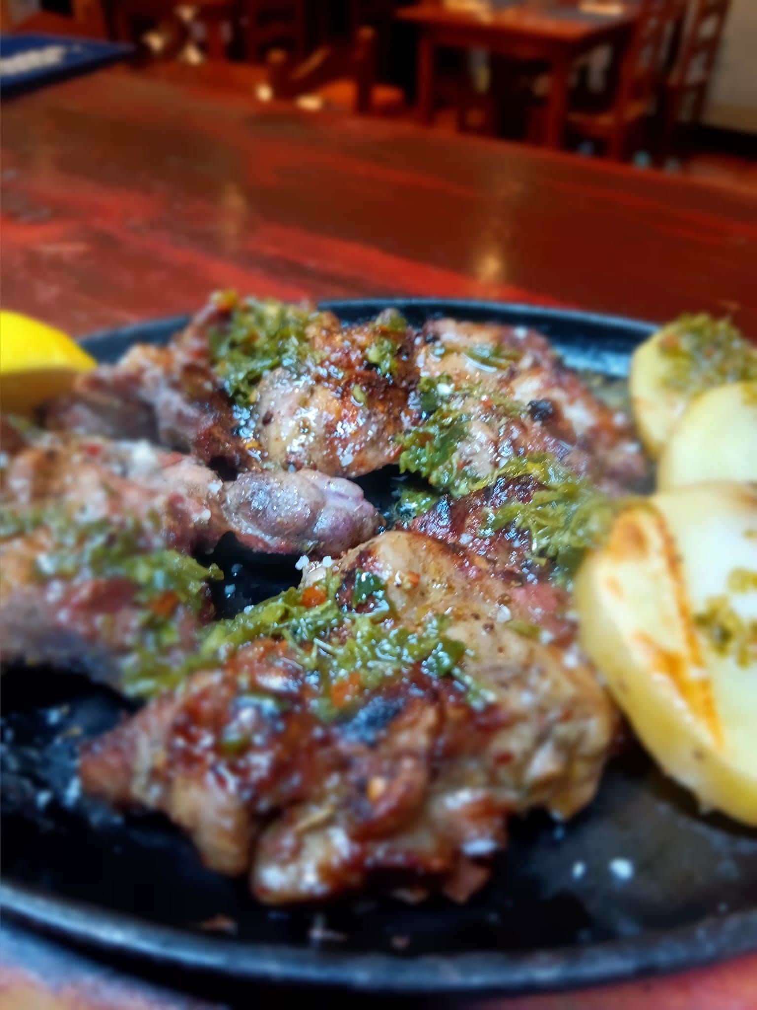 Un primer plano de un plato de carne y patatas sobre una mesa.