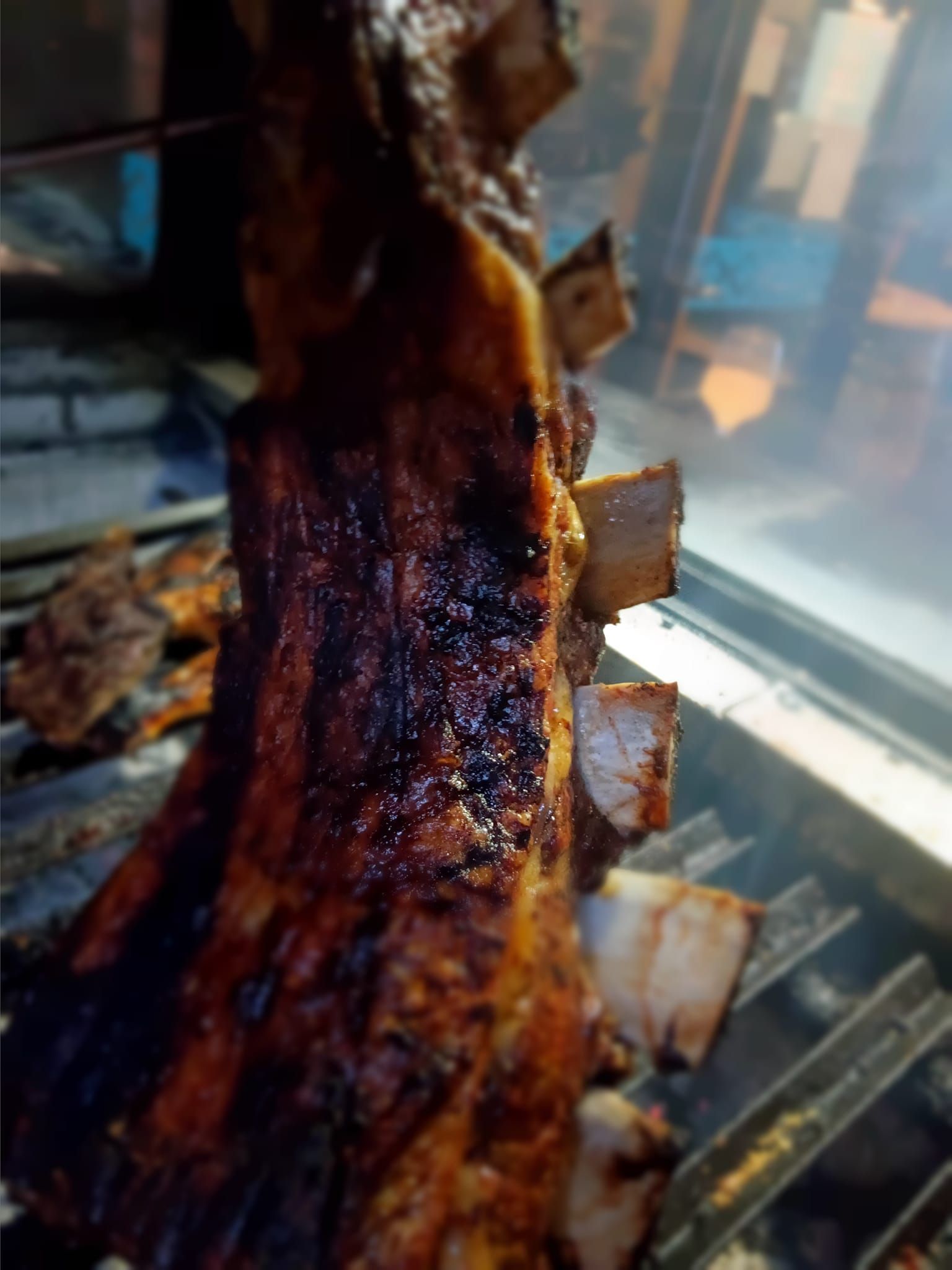 Se está cocinando un gran trozo de carne en una parrilla.