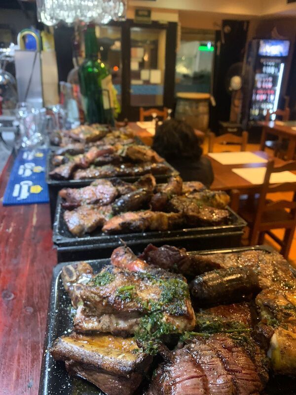 Una fila de platos de carne están alineados sobre una mesa en un restaurante.