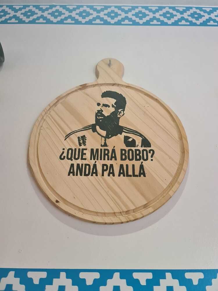 Una tabla de cortar de madera con la imagen de un hombre y las palabras