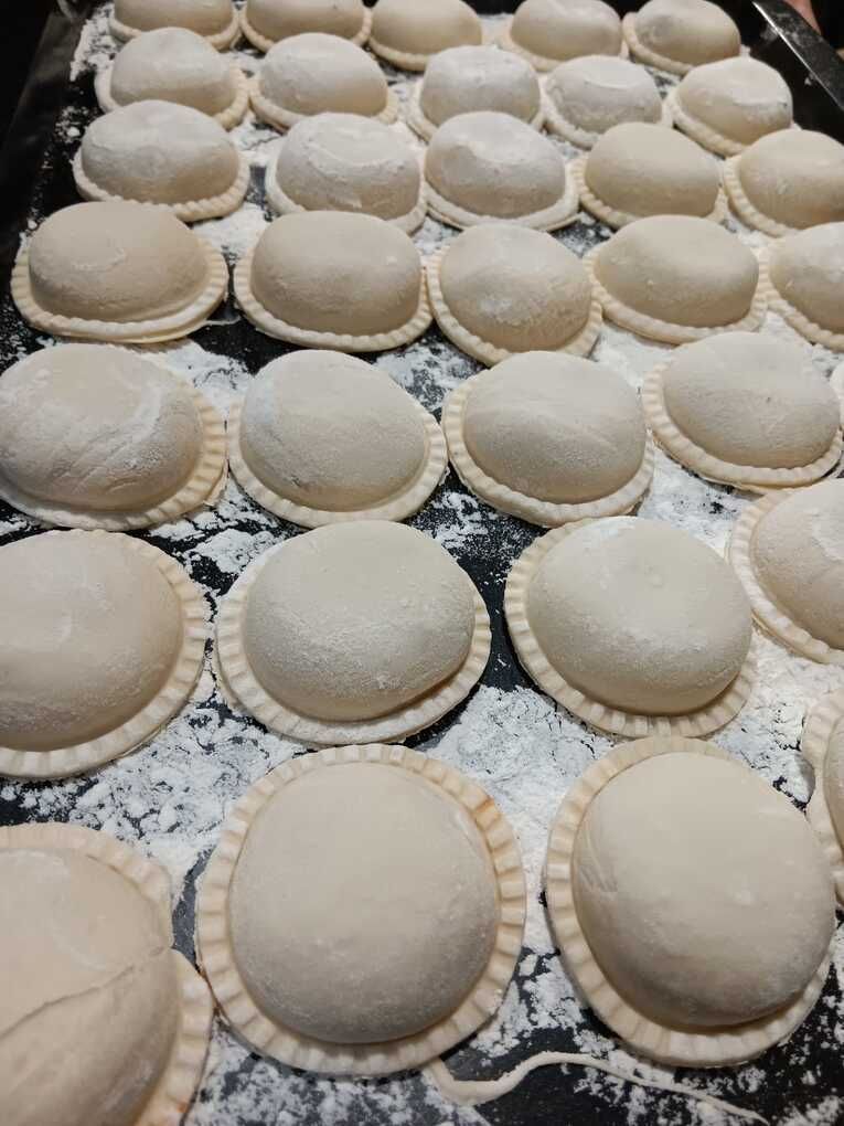 Un montón de bolas de masa colocadas encima de una mesa cubierta de harina.