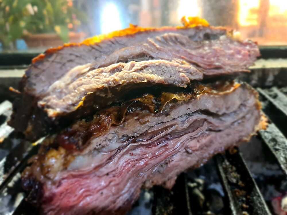 Se está cocinando un trozo de carne en una parrilla.