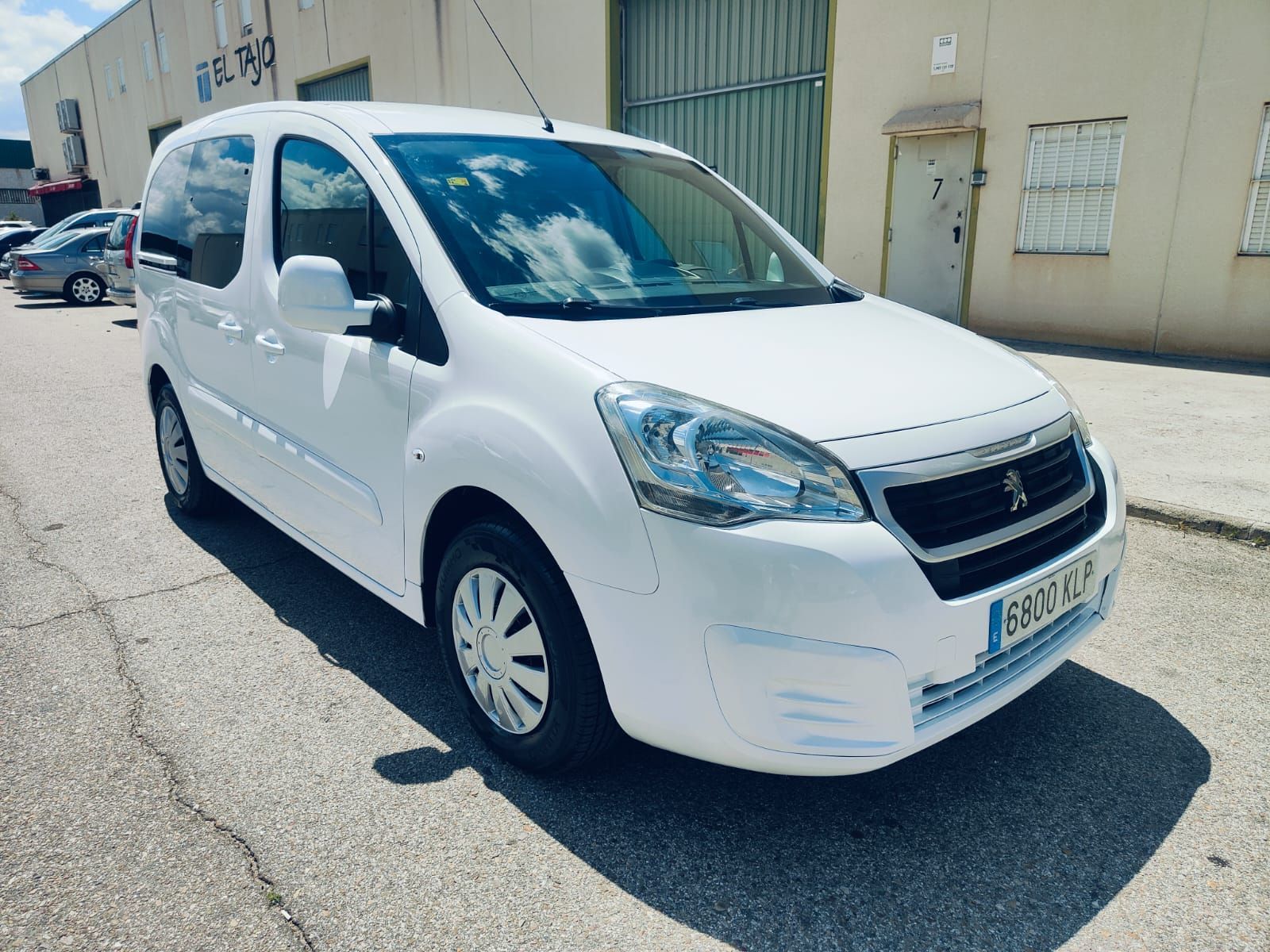 Una camioneta blanca está estacionada frente a un edificio.