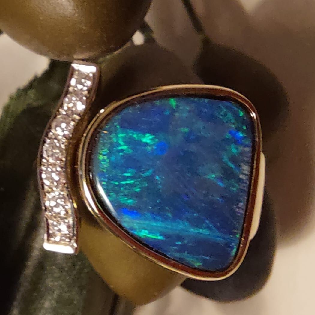 Ein goldener Ring mit Akzenten aus blauem Opal und Diamanten.